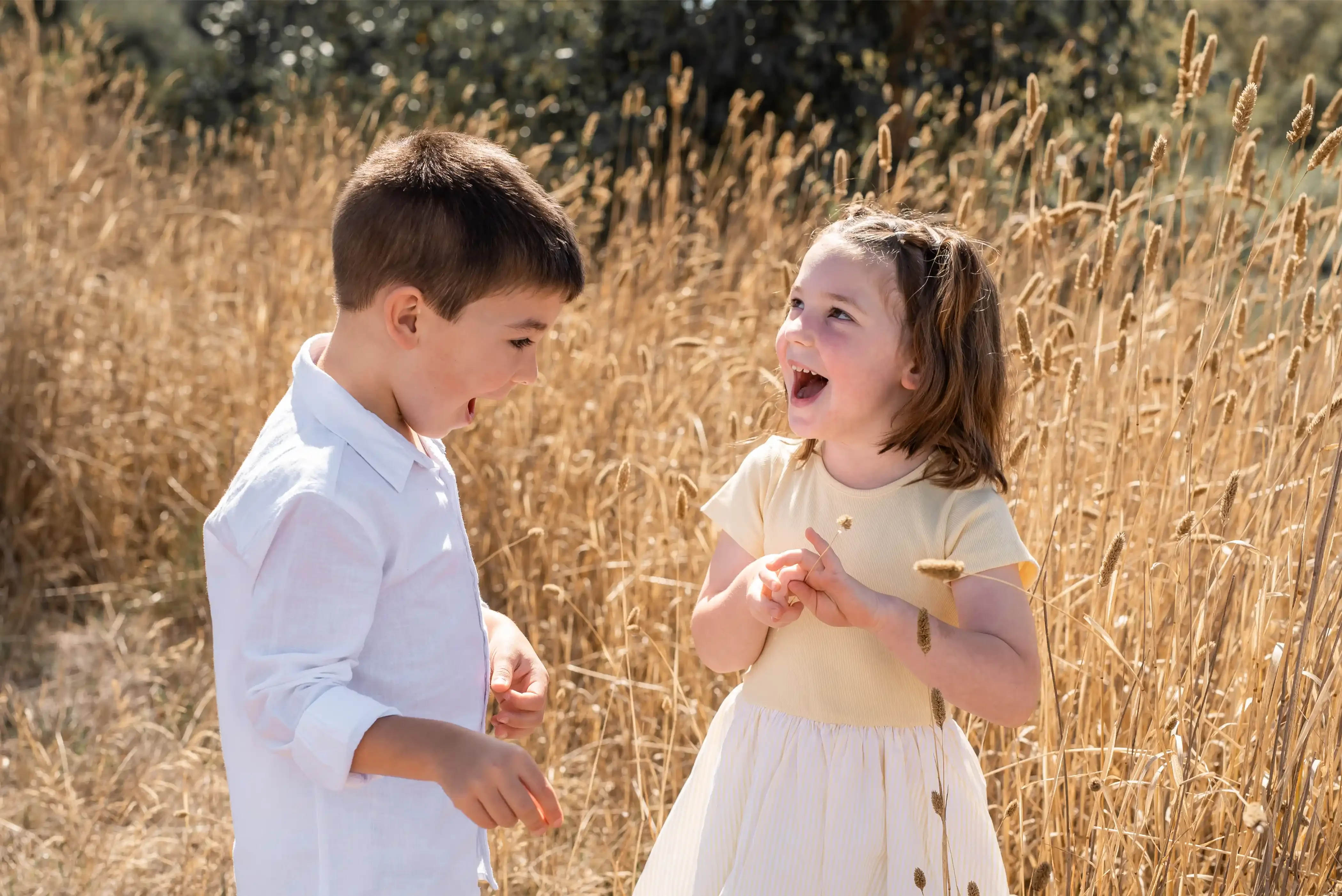 Siblings laughing playful outdoors
